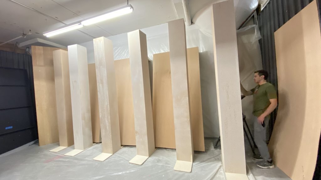 Tall unfinished scenic panels standing together in a workshop.
