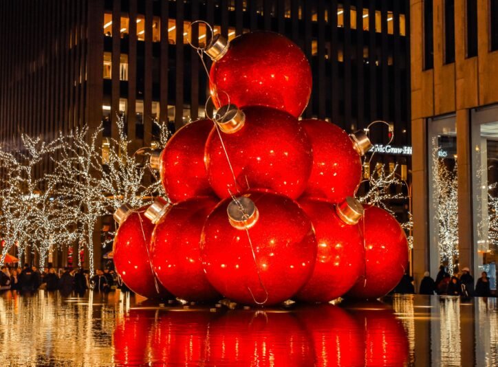 Oversized red Christmas ornaments displayed above a New York City fountain