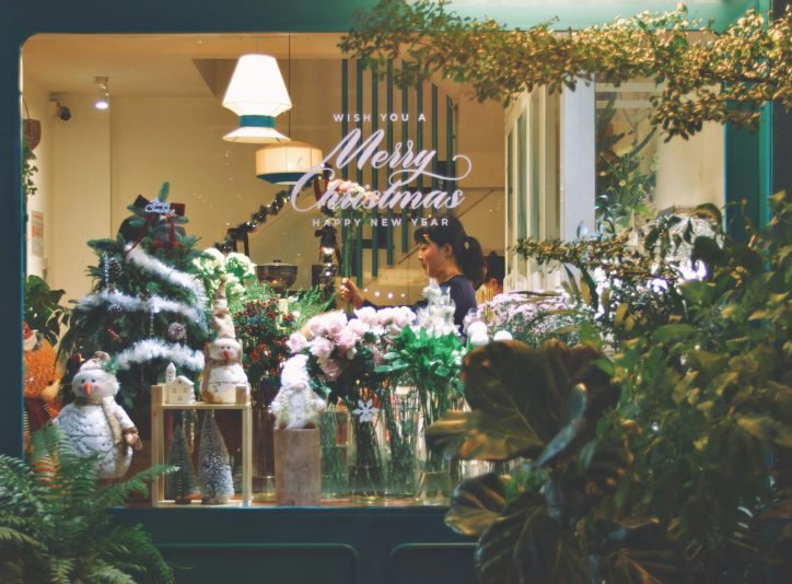 Shop window with Christmas lettering, trees, snowmen and flowers